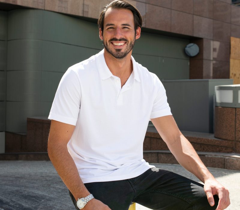 Handsome,Man,Smiling,In,White,Polo,Shirt,City,Portrait